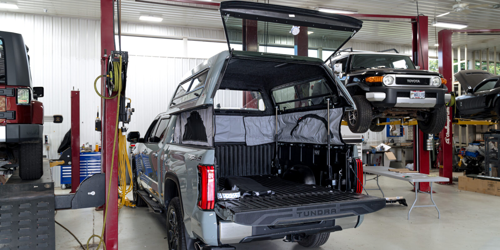 Grey Toyota Tundra with TopperLIft bed cap